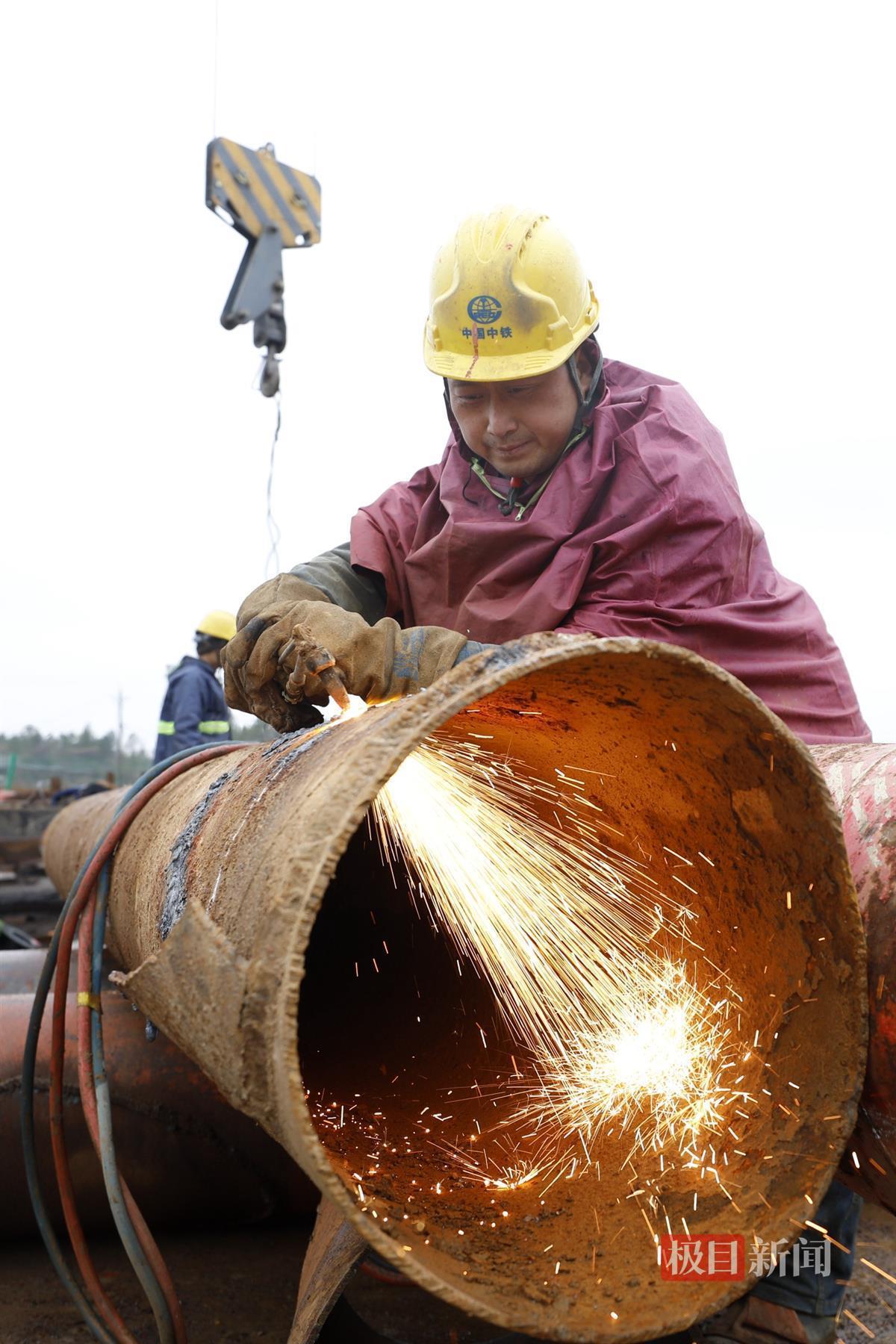 武汉地铁前川线二期“涉铁”高架段,地铁建设者切割钢管桩用于支架连接系。袁永华 摄.JPG